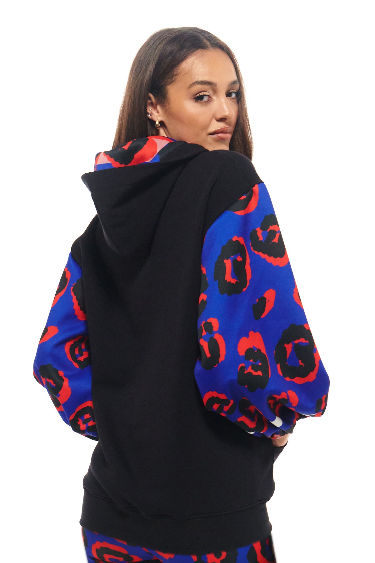 Streetwear-inspired black hoodie with kangaroo pocket and standout red and blue graphic print sleeves from RHOEN.