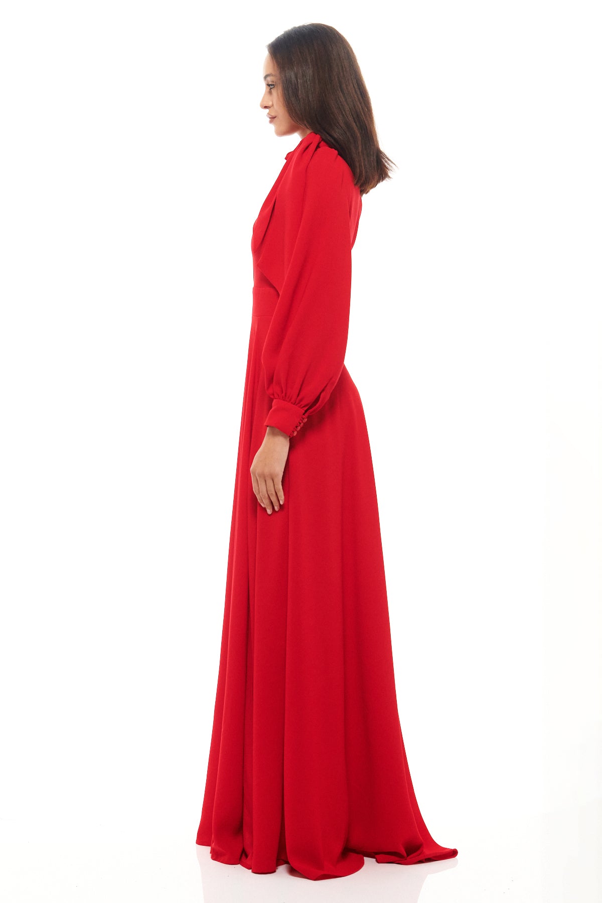 Statement red evening dress by Rhoen with one-shoulder silhouette, voluminous sleeve detail and fluid maxi-length hemline.