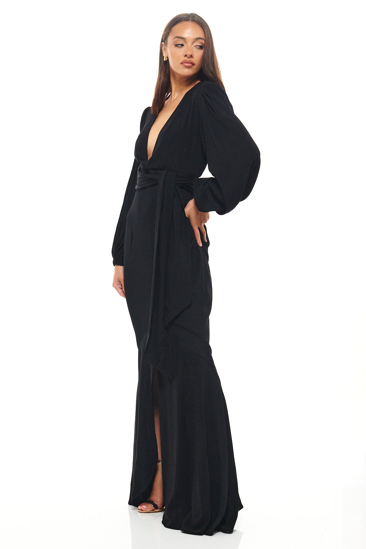 Full-length black Rhoen gown with deep V-front, puffed long sleeves and flowing fishtail hemline, blending timeless glamour with modern design.
