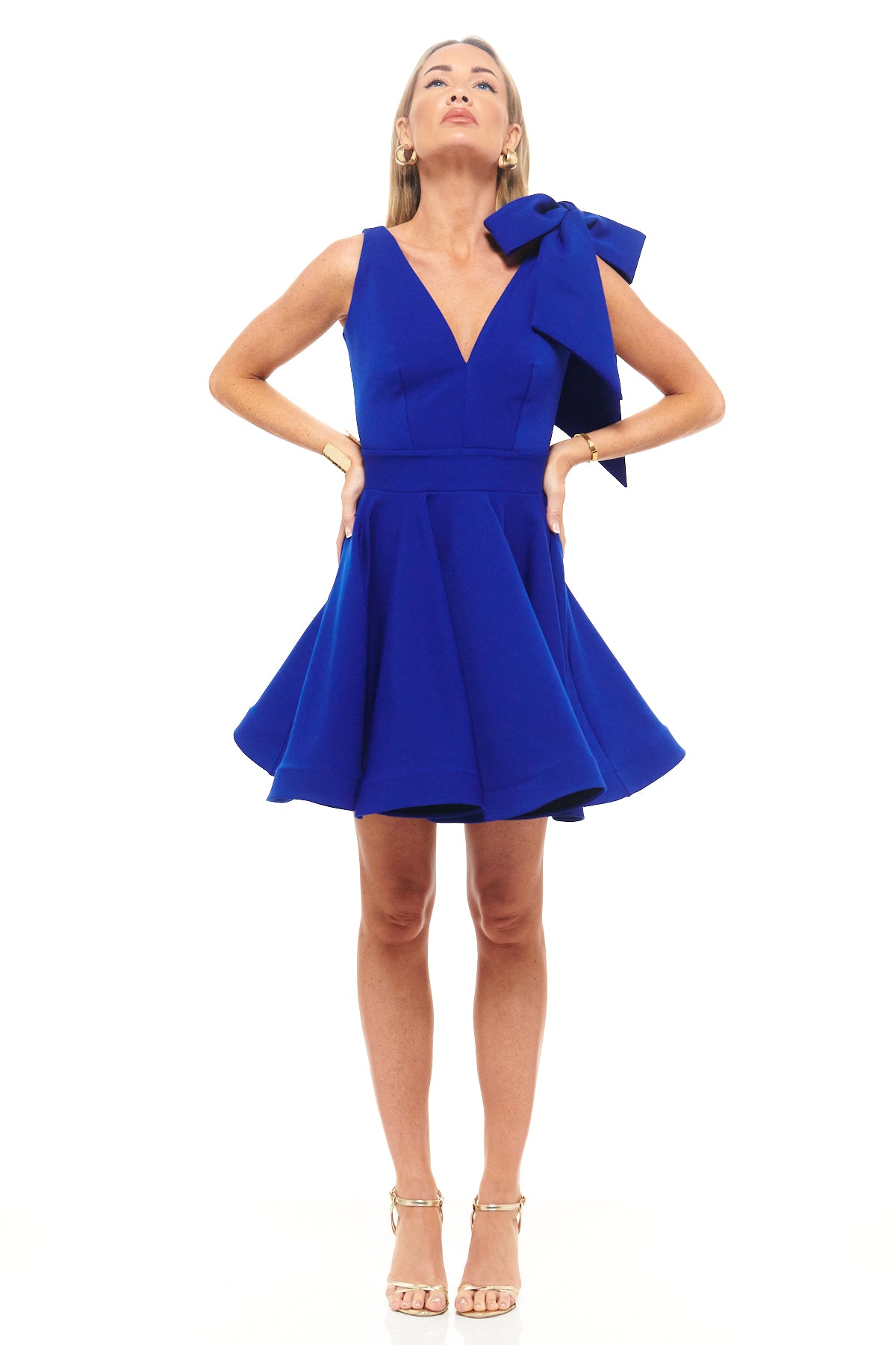 Bold cobalt blue cocktail dress by Rhoen featuring a flared skirt, plunging neckline and oversized shoulder bow for modern femininity.