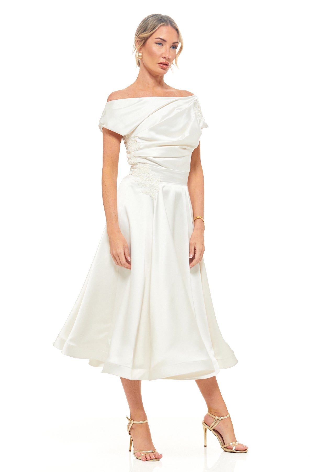 Elegant ivory satin dress from RHOEN, designed by Rebecca Rhoades, with asymmetric off-shoulder neckline, ruched detailing, and a soft full midi skirt – perfect for weddings and special occasions.