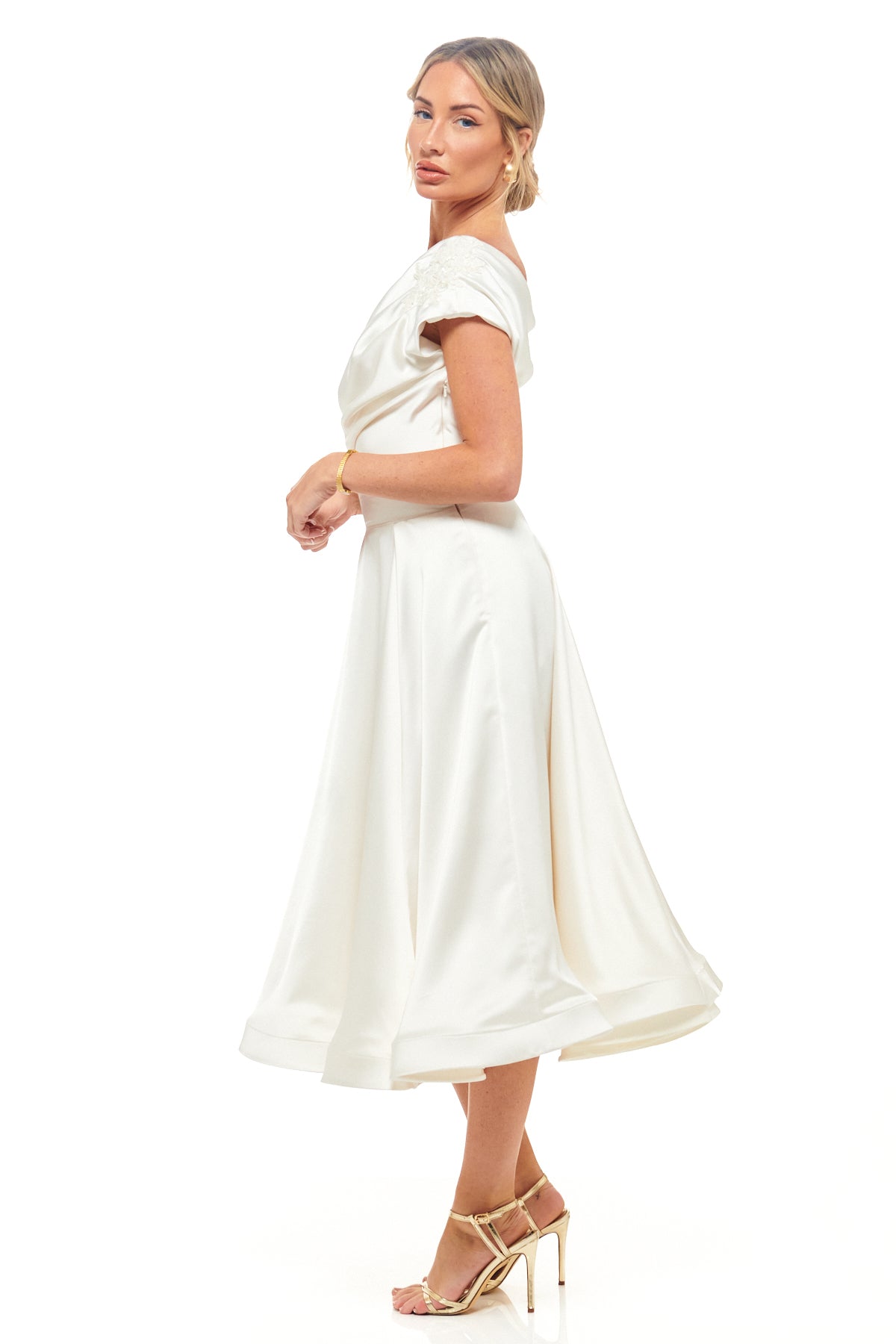 Ivory satin midi dress by RHOEN, originally Rebecca Rhoades design, featuring chic off-shoulder draping and a classic flowing skirt for bridal and evening events.