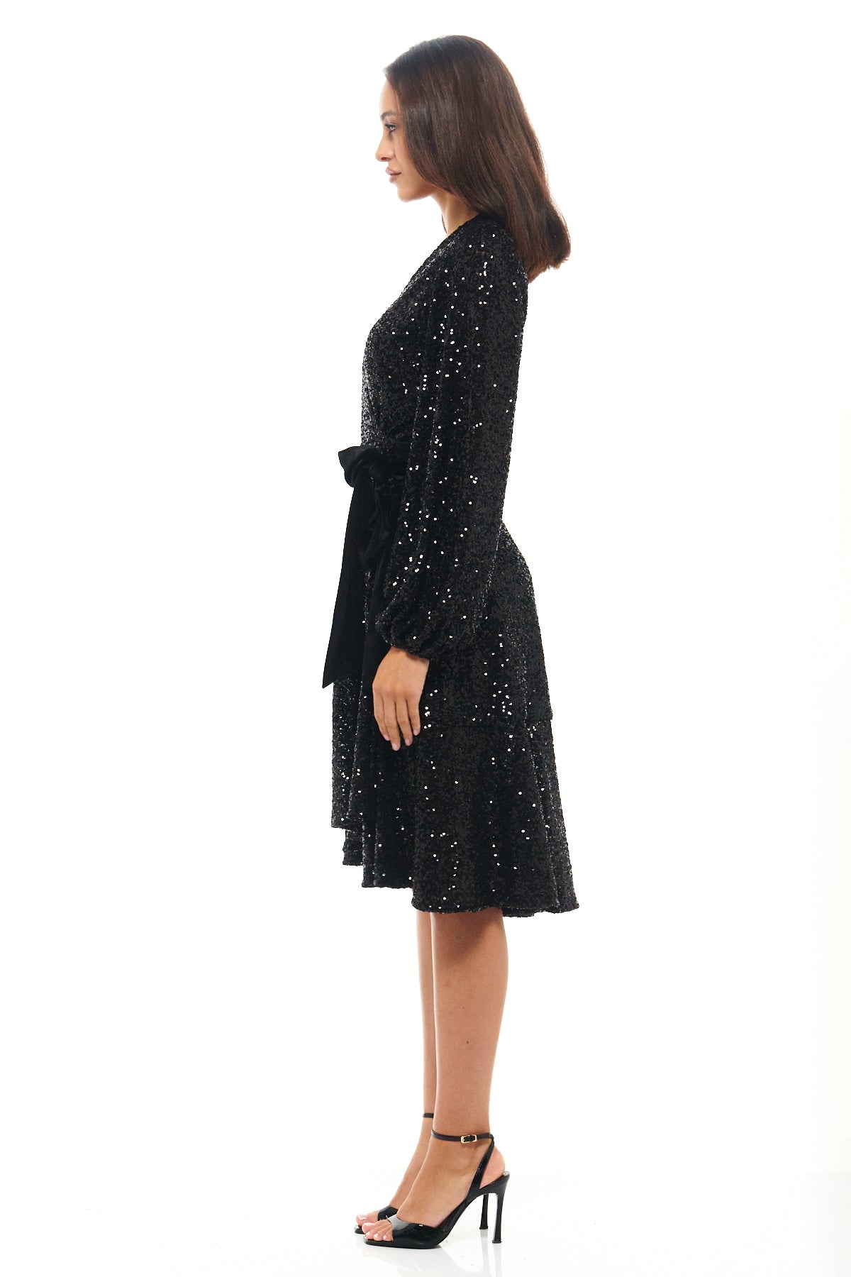 Shimmering black sequin wrap dress with subtle flared hemline, belted waist and long sleeves – a Rhoen design inspired by the signature sequin styles of Rebecca Rhoades.