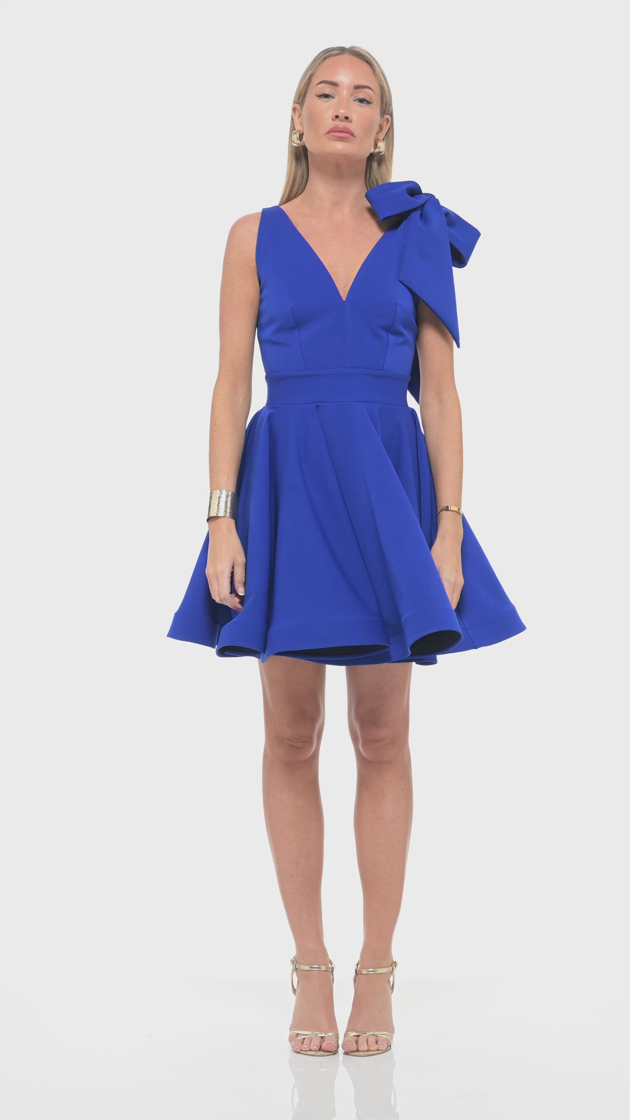 Rhoen contemporary mini dress in striking cobalt blue with tailored waist, voluminous skirt and bold shoulder bow embellishment.