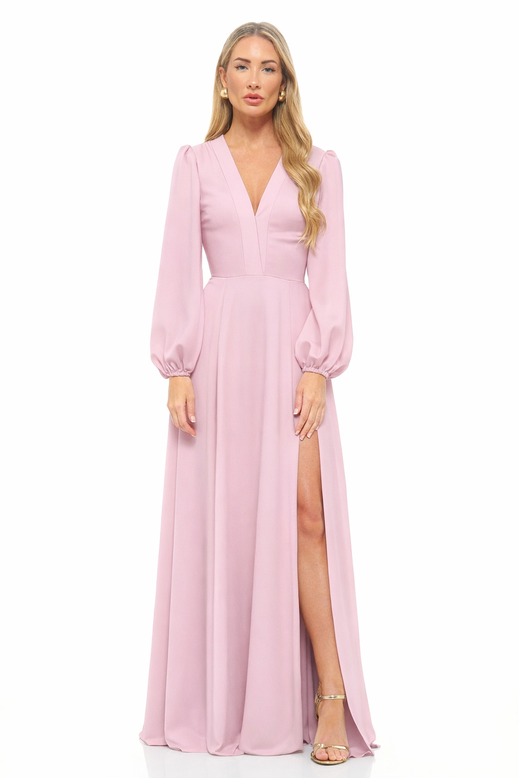 Woman wearing a pink evening gown with long sleeves and a slit on a white background