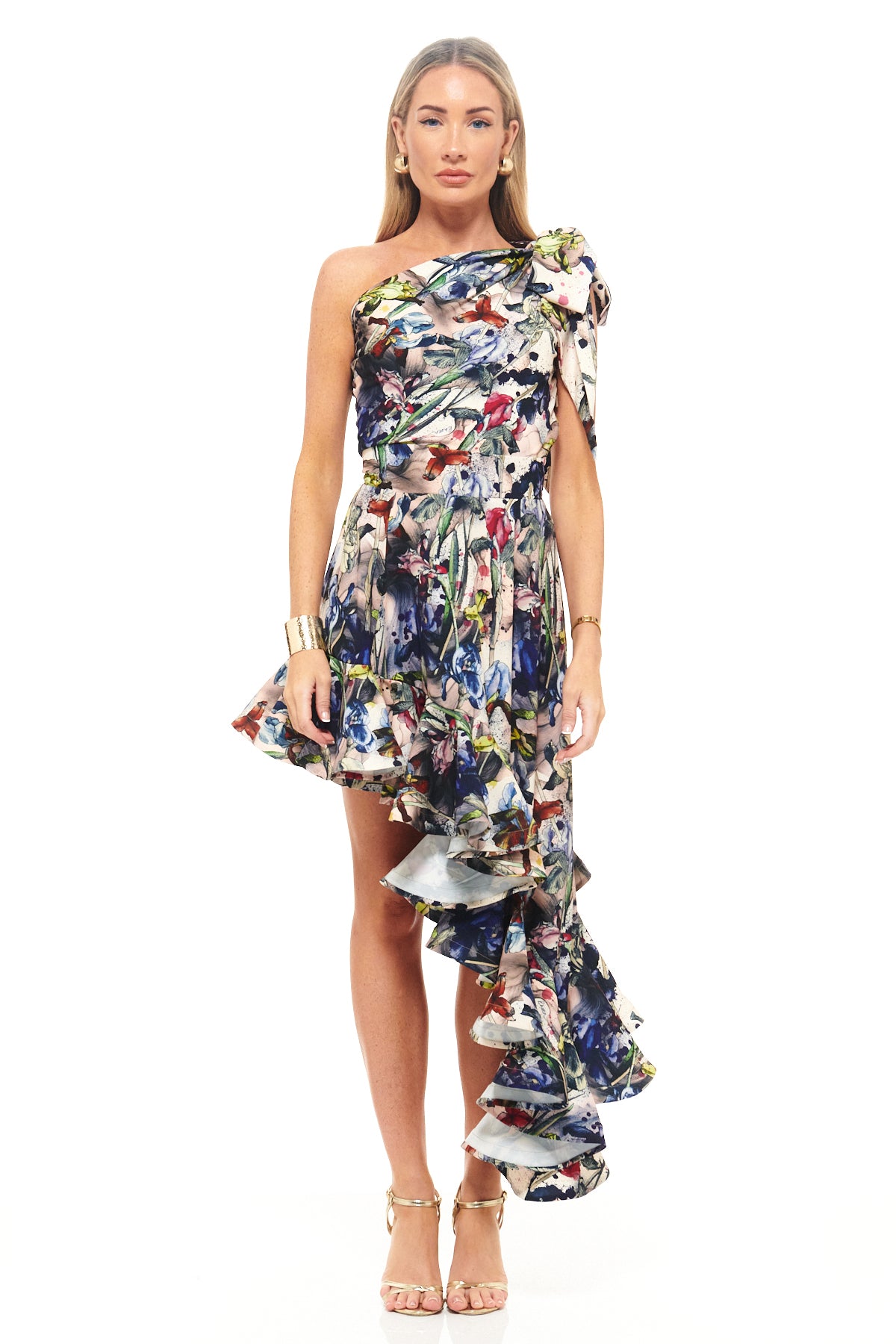 RHOEN one-shoulder asymmetric dress in bespoke floral print designed by Rebecca Rhoades, featuring a dramatic cascading ruffle hemline and fitted waist.