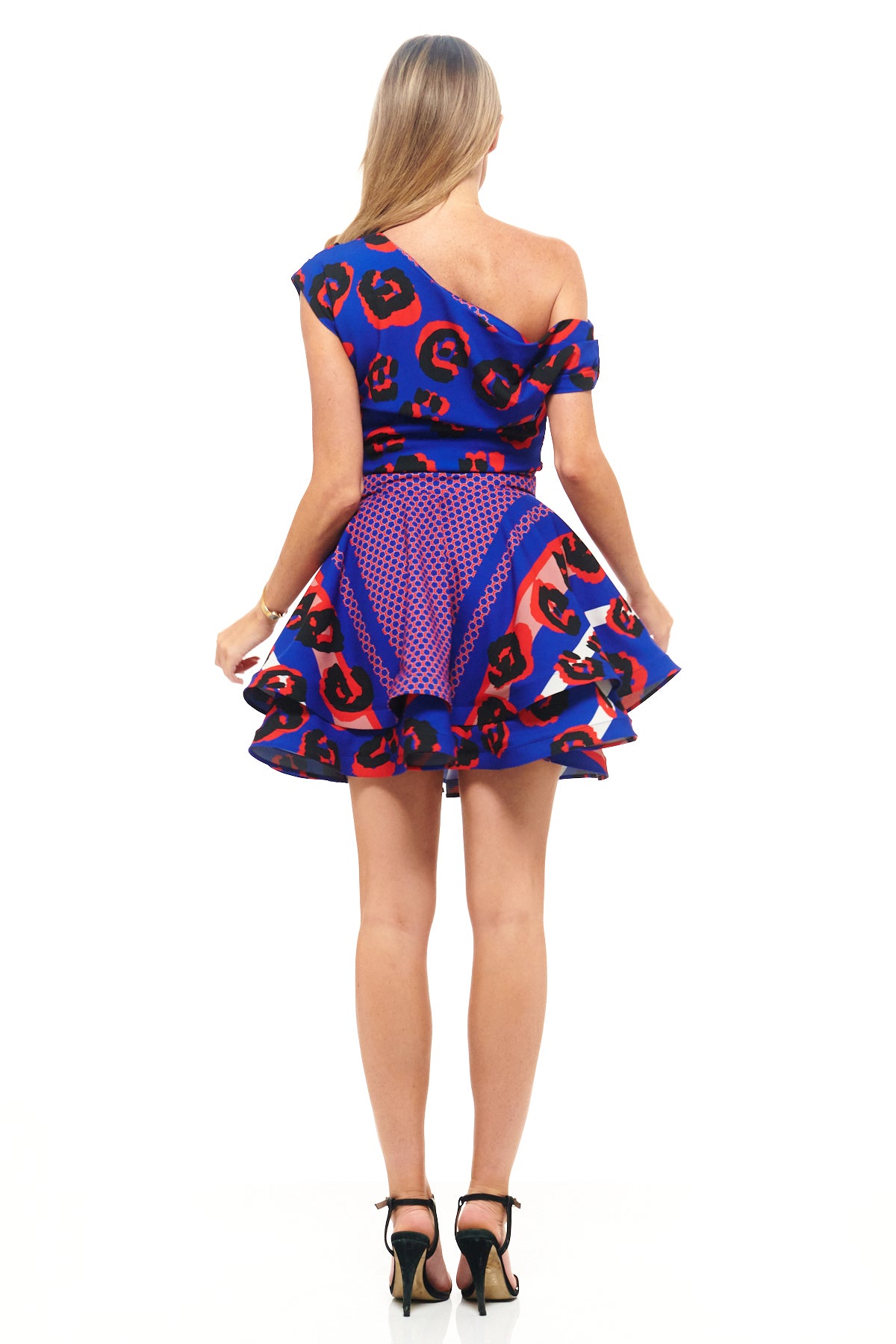 Designer mini dress by RHOEN in vibrant blue and red leopard print, featuring asymmetric one-shoulder cut and structured skater-style skirt.