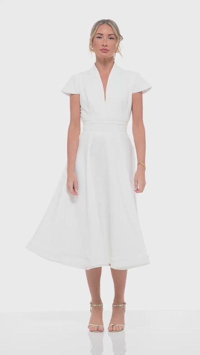 RHOEN ivory bridal midi dress with cap sleeves and tailored waistline, flowing into a structured skirt. Perfect for brides seeking a refined look for receptions, bridal showers, or post-ceremony celebrations.
